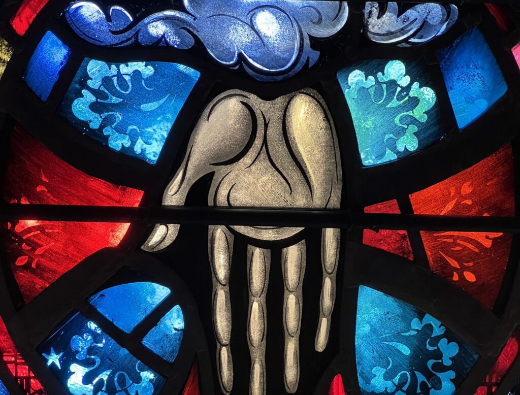 The hand of God the Father in red and blue stained glass