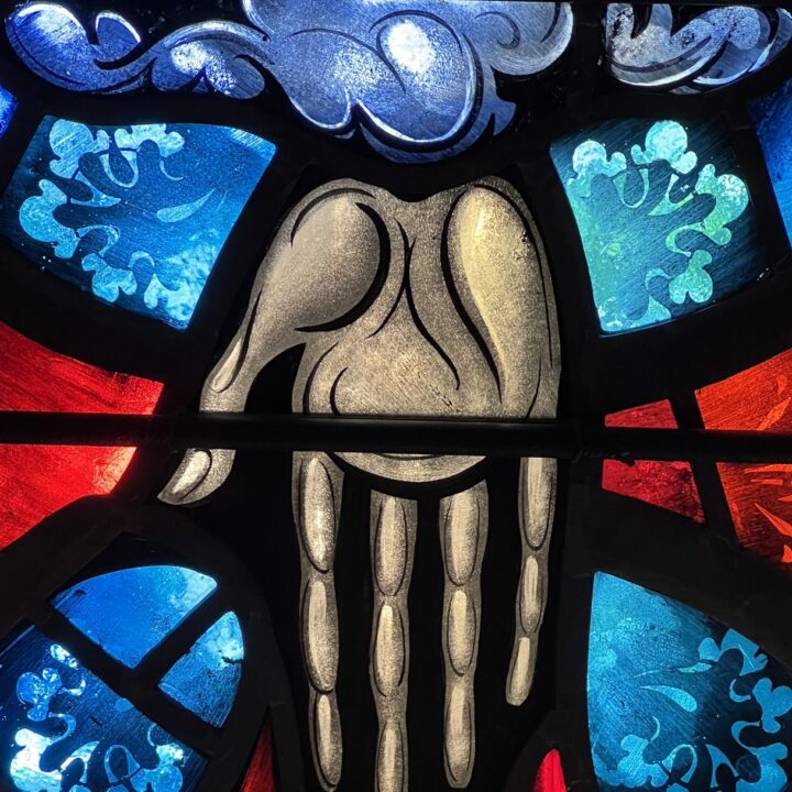 The hand of God the Father in red and blue stained glass